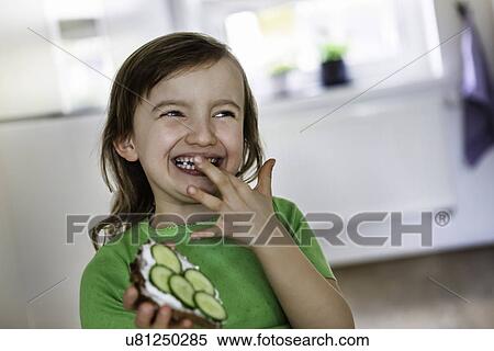 Stock Photography - Smiling girl with an open sandwich. Fotosearch