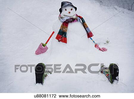 Stock Image - Snowman wearing hat and scarf. Fotosearch