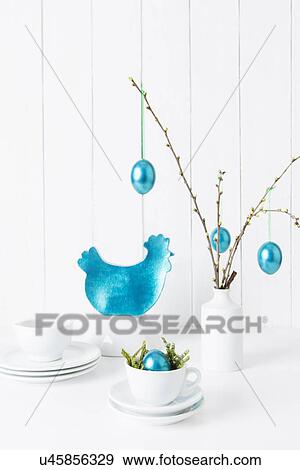 Still life of crockery and turquoise easter eggs hanging from twigs View Large Photo Image Stock Photo - Still life of crockery and turquoise easter eggs hanging from twigs. Fotosearch