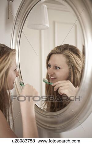 Teenage girl brushing her teeth in bathroom View Large Photo Image Stock Photo - Teenage girl brushing her teeth in bathroom. Fotosearch