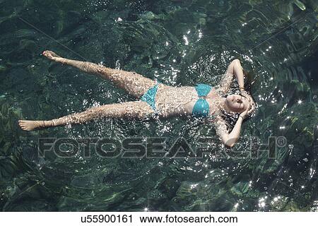 Teenage girl floating with eyes closed in sea View Large Photo Image Stock Image - Teenage girl floating with eyes closed in sea. Fotosearch