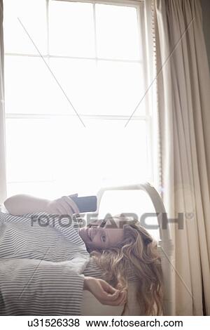 Teenage girl looking at cellphone in bed View Large Photo Image Stock Photo - Teenage girl looking at cellphone in bed. Fotosearch