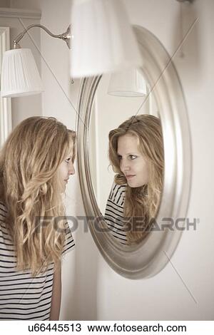 Teenage girl looking at herself in bathroom mirror View Large Photo Image Stock Image - Teenage girl looking at herself in bathroom mirror. Fotosearch