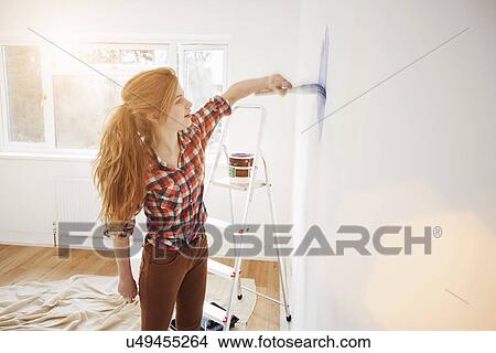 Teenage girl painting her bedroom wall View Large Photo Image Picture - Teenage girl painting her bedroom wall. Fotosearch