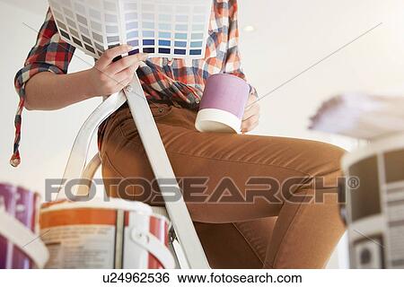 Stock Photograph - Teenage girl sitting on stepladders with coffee and swatch. Fotosearch