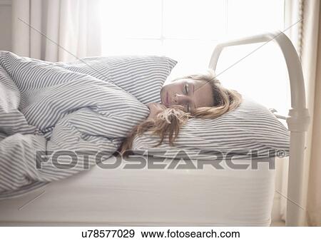 Stock Photo - Teenage girl sleeping in bed. Fotosearch