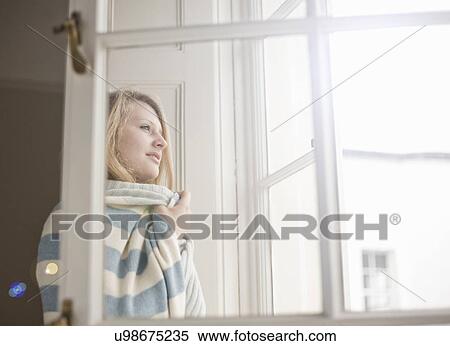 Teenage girl wrapped in a blanket looking out of patio door View Large Photo Image Stock Photography - Teenage girl wrapped in a blanket looking out of patio door. Fotosearch