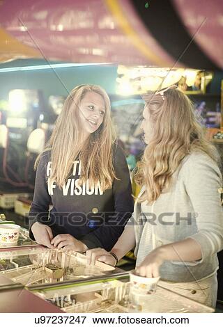 Teenage sisters chatting in amusement arcade View Large Photo Image Stock Photo - Teenage sisters chatting in amusement arcade. Fotosearch