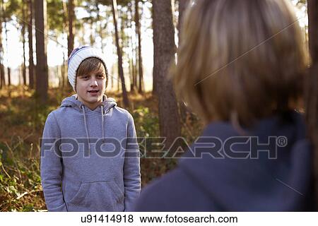 Stock Photo - Twin brothers face to face in woods. Fotosearch