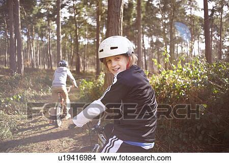 Picture - Twin brothers on BMX bikes in forest. Fotosearch