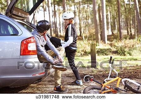 Stock Photo - Twin brothers preparing to ride BMX bikes in forest. Fotosearch