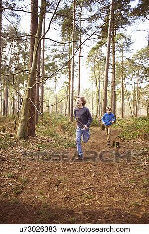Twin brothers racing each other through forest View Large Photo Image Stock Image - Twin brothers racing each other through forest. Fotosearch