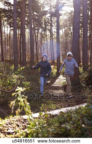 Twin brothers racing through forest View Large Photo Image Stock Image - Twin brothers racing through forest. Fotosearch