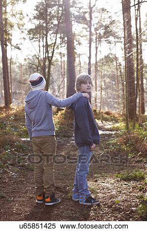 Stock Photography - Twin brothers standing together in woods. Fotosearch