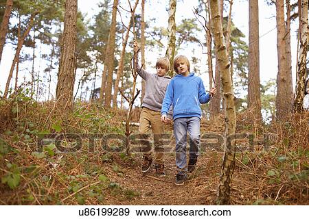 Stock Photo - Twin brothers strolling in woods. Fotosearch