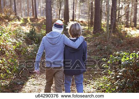 Stock Photograph - Twin brothers walking together in woods. Fotosearch