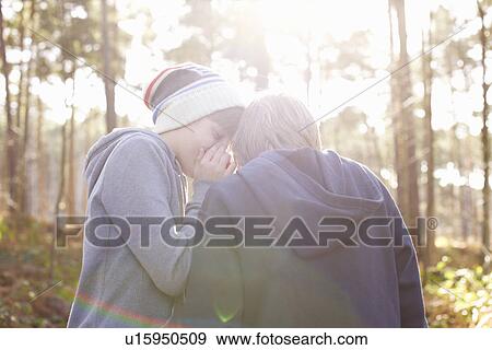 Twin brothers whispering plans in woods View Large Photo Image Stock Photo - Twin brothers whispering plans in woods. Fotosearch