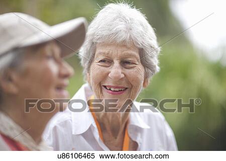 Two senior women chatting in retirement villa garden View Large Photo Image Stock Photography - Two senior women chatting in retirement villa garden. Fotosearch