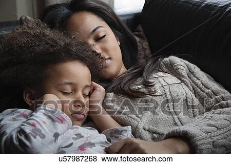Stock Photo - Two sisters asleep on sofa. Fotosearch