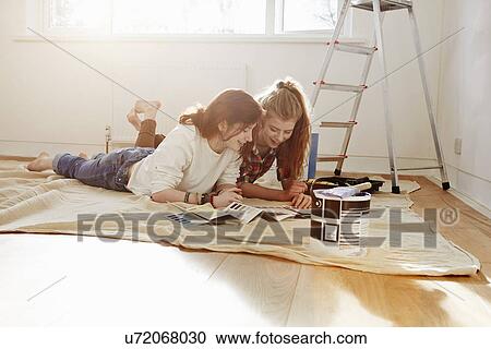 Two teenage sisters lying on floor looking at color swatches View Large Photo Image Stock Image - Two teenage sisters lying on floor looking at color swatches. Fotosearch