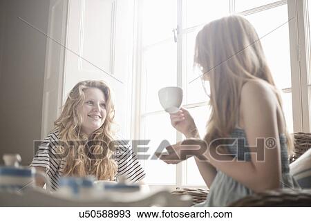 Two teenage sisters sharing traditional afternoon tea View Large Photo Image Stock Image - Two teenage sisters sharing traditional afternoon tea. Fotosearch