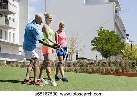 Two young women and trainer using exercise ropes in park View Large Photo Image Stock Image - Two young women and trainer using exercise ropes in park. Fotosearch