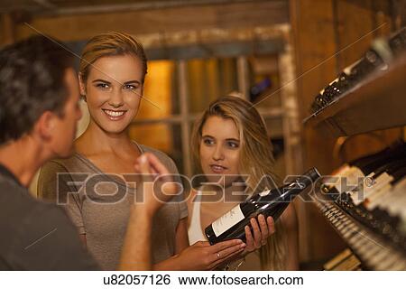 Two young women choosing wine in wine shop View Large Photo Image Stock Photograph - Two young women choosing wine in wine shop. Fotosearch