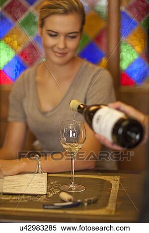 Waiter pouring glass of white wine for a young woman View Large Photo Image Stock Photography - Waiter pouring glass of white wine for a young woman. Fotosearch