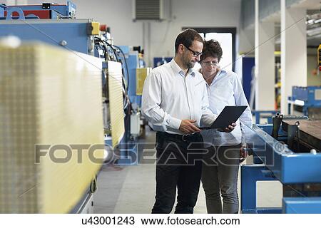 Work colleagues checking information on laptop View Large Photo Image Stock Image - Work colleagues checking information on laptop. Fotosearch