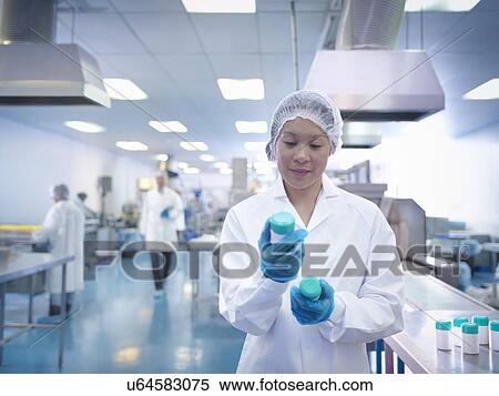 Stock Photography - Worker inspecting packaging in pharmaceutical factory. Fotosearch