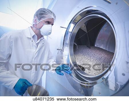 Stock Photography - Worker using tablet coating machine in pharmaceutical factory. Fotosearch