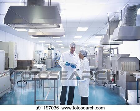 Stock Photograph - Workers in discussion in pharmaceutical factory. Fotosearch