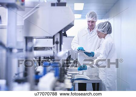 Workers inspecting product in pharmaceutical factory View Large Photo Image Stock Photo - Workers inspecting product in pharmaceutical factory. Fotosearch