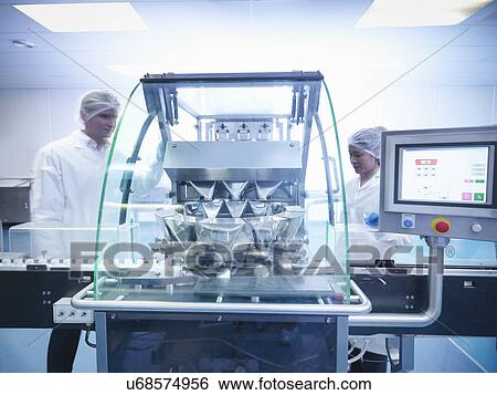 Workers inspecting tablets as they are put into packaging in pharmaceutical factory View Large Photo Image Stock Photograph - Workers inspecting tablets as they are put into packaging in pharmaceutical factory. Fotosearch