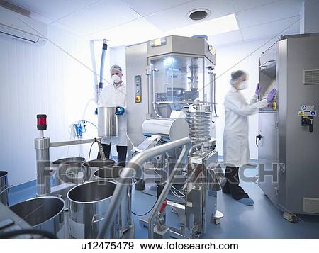 Stock Photo - Workers with tablet pressing machine in pharmaceutical factory. Fotosearch