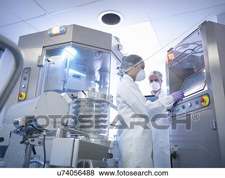 Workers with tablet pressing machine in pharmaceutical factory View Large Photo Image Stock Photo - Workers with tablet pressing machine in pharmaceutical factory. Fotosearch