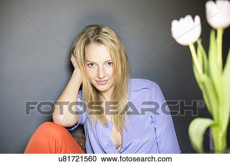Stock Image - Young blonde woman wearing blue blouse. Fotosearch