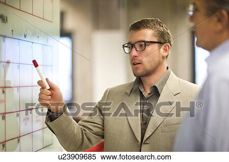 Stock Photography - Young businessman presenting ideas to client. Fotosearch
