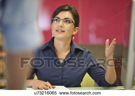 Young businesswoman advising colleague in office View Large Photo Image Stock Photography - Young businesswoman advising colleague in office. Fotosearch