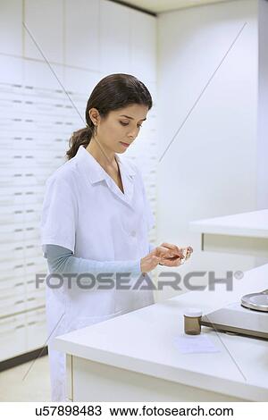Young female pharmacist weighing medicines in pharmacy View Large Photo Image Stock Image - Young female pharmacist weighing medicines in pharmacy. Fotosearch