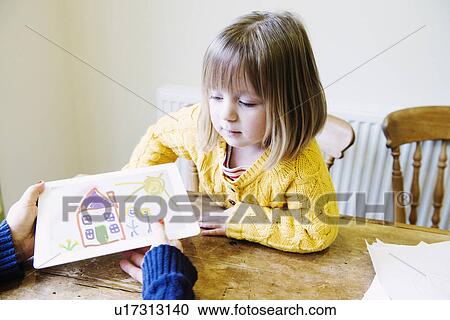 Young girl and mother at kitchen looking at drawing View Large Photo Image Stock Image - Young girl and mother at kitchen looking at drawing. Fotosearch
