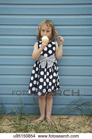 Young girl enjoying ice cream next to beach hut View Large Photo Image Picture - Young girl enjoying ice cream next to beach hut. Fotosearch