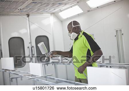 Young man spraying wooden products in carpenters workshop View Large Photo Image Stock Photograph - Young man spraying wooden products in carpenters workshop. Fotosearch