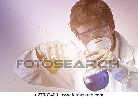 Young scientist carefully mixing flasks of liquid View Large Photo Image Stock Image - Young scientist carefully mixing flasks of liquid. Fotosearch