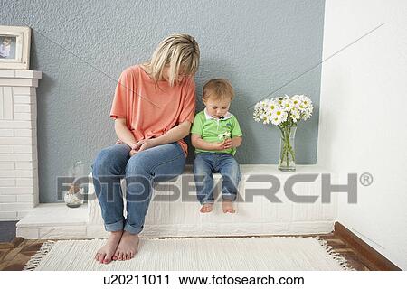 Young woman and baby boy playing with flowers View Large Photo Image Stock Image - Young woman and baby boy playing with flowers. Fotosearch