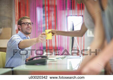 Young woman handing coffee to male colleague in office View Large Photo Image Stock Image - Young woman handing coffee to male colleague in office. Fotosearch