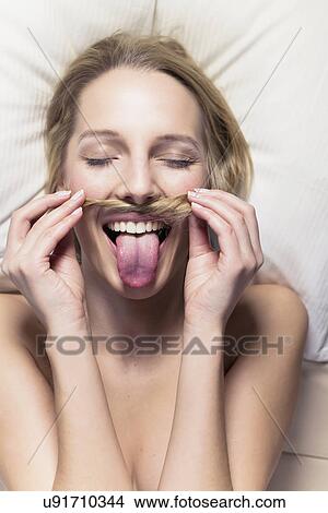 Young woman holding hair to imitate moustache View Large Photo Image Picture - Young woman holding hair to imitate moustache. Fotosearch