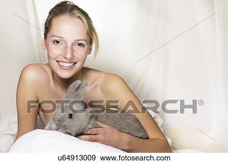 Young woman holding rabbit View Large Photo Image Stock Photo - Young woman holding rabbit. Fotosearch