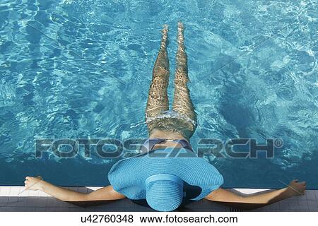 Stock Photo - Young woman relaxing in swimming pool. Fotosearch