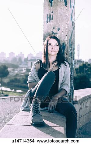 Young woman sitting on wall View Large Photo Image Picture - Young woman sitting on wall. Fotosearch